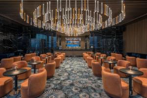 a lobby with chairs and tables and a chandelier at Cap St Georges Hotel & Resort in Peyia