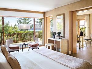 een slaapkamer met een groot bed en een groot raam bij Cape Sounio Grecotel Boutique Resort in Sounio