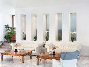 salon z białymi kanapami i stołami w obiekcie Grand Leoniki Residence by Grecotel w mieście Platanes