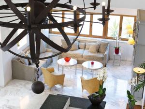 a living room with a couch and a chandelier at Grand Leoniki Residence by Grecotel in Platanes