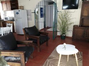 een woonkamer met stoelen en een tafel en een koelkast bij Balak in Punta del Este