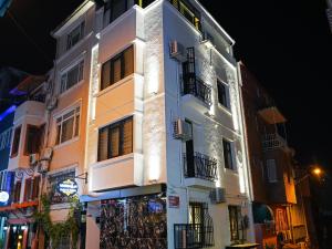 a white building with balconies on a street at night at Whıte Moon Hotel Suites in Istanbul