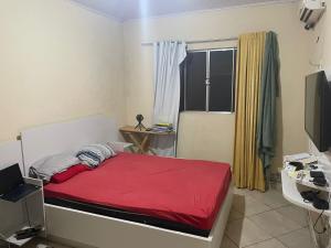 um quarto com uma cama vermelha e uma janela em Lohighfive em Florianópolis