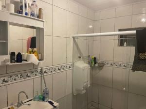 a white bathroom with a sink and a mirror at Lohighfive in Florianópolis