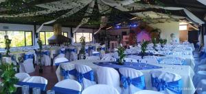 a banquet hall with white tables and chairs with blue bows at Hotel Chimeneas del Dorado in Sesquilé