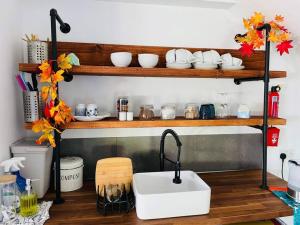 a kitchen with a sink and a shelf with dishes at Preachers Rest in Killough