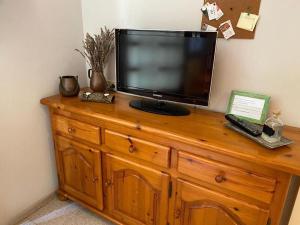 a television sitting on top of a wooden dresser at Rural apartment with nice views and shared pool in Montseny
