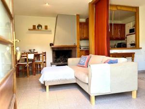 a living room with a couch and a table and a kitchen at Rural apartment with nice views and shared pool in Montseny