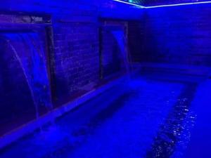 a dark room with a pool with blue lights at مزرعة طلة الهيبة in Jal‘ad