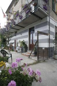 a building with a balcony and flowers in front of it at B&B Jolly Gorreto in Gorreto