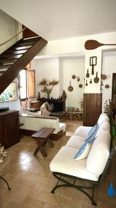 een woonkamer met witte banken en een trap bij Villa La Rucchetta Alghero in Alghero