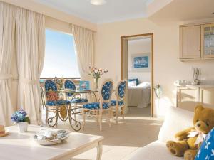 a living room with a teddy bear sitting on a couch at Grecotel Marine Palace & Aqua Park in Panormos Rethymno