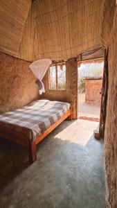 um quarto com uma cama num quarto com uma janela em Muke Village Guest House em Livingstone