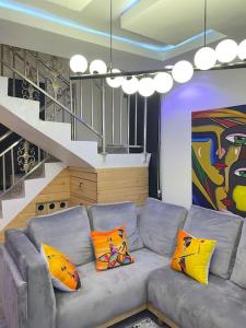 a living room with a gray couch with colorful pillows at Modern 1bedroom Duplex in Port Harcourt