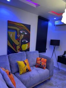 a living room with a couch with pillows and a painting at Modern 1bedroom Duplex in Port Harcourt