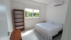 フロリアノポリスにあるCasa c/ SPA e mesa de sinuca 240 m2の白いベッドルーム(ベッド1台、窓付)