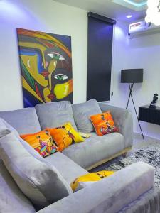 a living room with a gray couch with colorful pillows at Modern 1bedroom Duplex in Port Harcourt