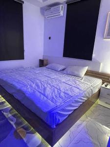 a bedroom with a bed with a blue comforter at Modern 1bedroom Duplex in Port Harcourt