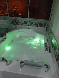 Hotel Casa Blanca في Aguadas: حوض استحمام به ماء أخضر وأضواء فيه