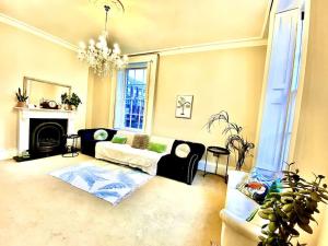 a living room with a couch and a chandelier at Luxury Georgian Townhouse - Central Liverpool Location (Falkner St) in Liverpool