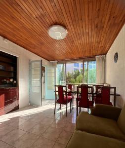 a dining room with a table and chairs and a wooden ceiling at Appartement familial à Paris in Villejuif