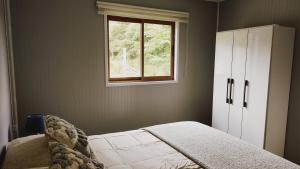 1 dormitorio con cama y ventana en Cabañas Altos de Nalhuitad, en Chonchi
