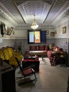 a living room with couches and a chandelier at La Casa Del Colonel in Marrakesh