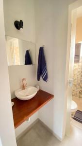 ein Bad mit einem Waschbecken und einem Spiegel in der Unterkunft Espaço Zoey in Búzios