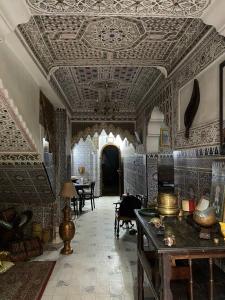 an ornate room with a ceiling and a room with tables at La Casa Del Colonel in Marrakesh