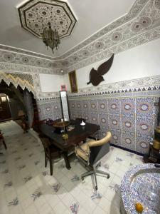 a room with a piano and a table and a chair at La Casa Del Colonel in Marrakesh