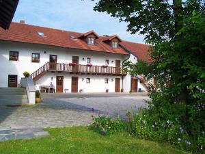 ein großes weißes Gebäude mit rotem Dach in der Unterkunft Pension Margaretenhof in Bayerbach