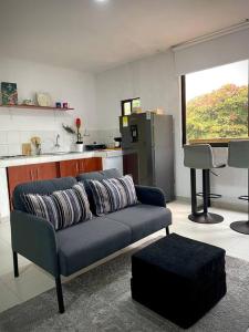 Apartaestudio Zona Norte - Vipasa في كالي: غرفة معيشة مع أريكة زرقاء ومطبخ