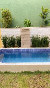 a swimming pool in a garden with plants at Espaço Zoey in Búzios