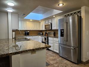cocina con armarios blancos y nevera de acero inoxidable en Waterfront, Camelback Mountain, Golf Course View N, en Scottsdale
