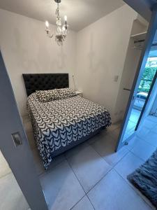 1 dormitorio con cama y lámpara de araña en Belgrano Chic apartament en Buenos Aires