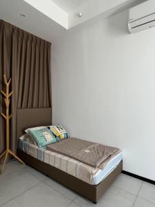 uma pequena cama num quarto com uma janela em Georgetown Comfy Homestay em Jelutong