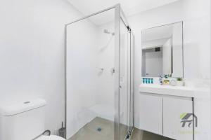 Un baño blanco con ducha y lavabo. en Van Gogh's Condo in Parramatta, en Sídney 40 fotos más