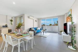 Una cocina y una sala de estar con mesa y sillas. en Van Gogh's Condo in Parramatta, en Sídney