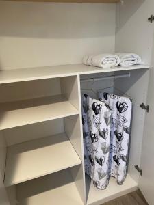 un vestidor con estantes blancos y toallas en Orchard house en Los Ángeles