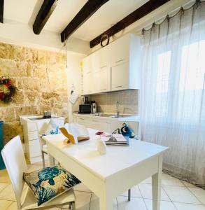 a kitchen with a white table and chairs at Picasso Art Room Studio Apartment in Alghero