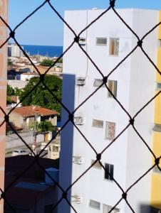 - une vue sur un bâtiment blanc derrière une clôture dans l'établissement Temporada em Maceió, à Maceió