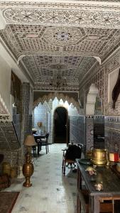 a room with a ceiling with a table and chairs at La Casa Del Colonel in Marrakesh