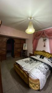 sypialnia z łóżkiem i żyrandolem w obiekcie La Casa Del Colonel w Marakeszu