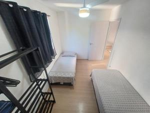an empty room with two beds and a stair case at Apê no Centro de Madureira in Rio de Janeiro