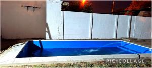 uma piscina azul ao lado de uma cerca branca em C & J Casa de alquiler em Maco