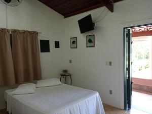 a bedroom with a white bed and a window at Pousada Chácara VIVALLI in Holambra