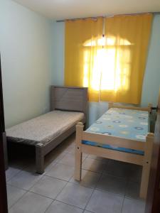 ein kleines Schlafzimmer mit 2 Betten und einem Fenster in der Unterkunft Casa verde in Pontal do Paraná