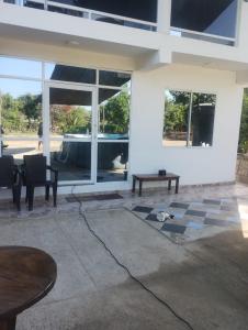 eine Terrasse mit einem Tisch und Stühlen vor einem Gebäude in der Unterkunft Cabaña frente a la playa in Tubará