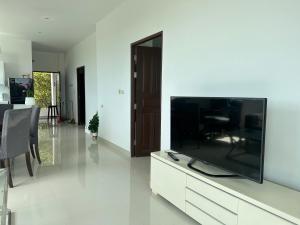 a living room with a flat screen tv on a cabinet at 2 Bedroom Seaview Apartment Lanta Sport Resort 305 in Phra Ae beach