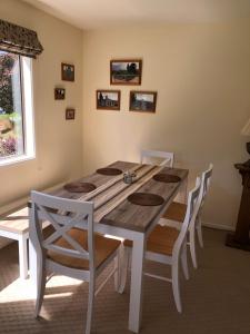 uma sala de jantar com uma mesa e cadeiras e uma janela em Jennifer's Cottage 